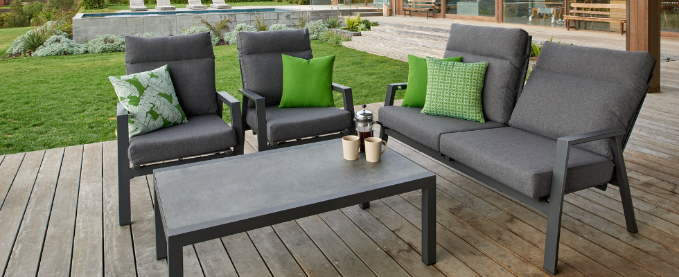Ballina aluminium outdoor recliner setting in charcoal on a timber deck next to a grass area.