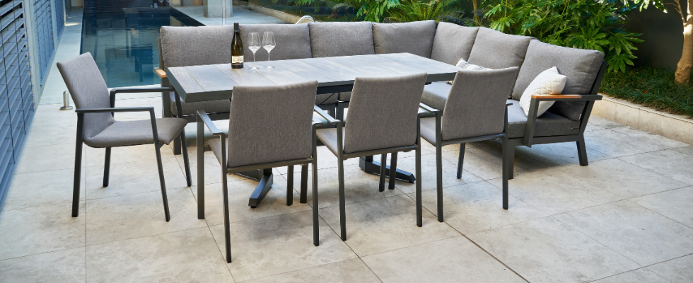 Lorne outdoor lounge with Torquay adjustable height table and dining chairs on a tiled patio next to a pool