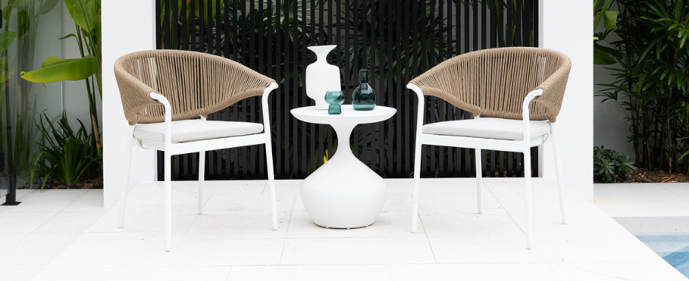 2 small profile wicker backed chairs with thin white frame and small side table