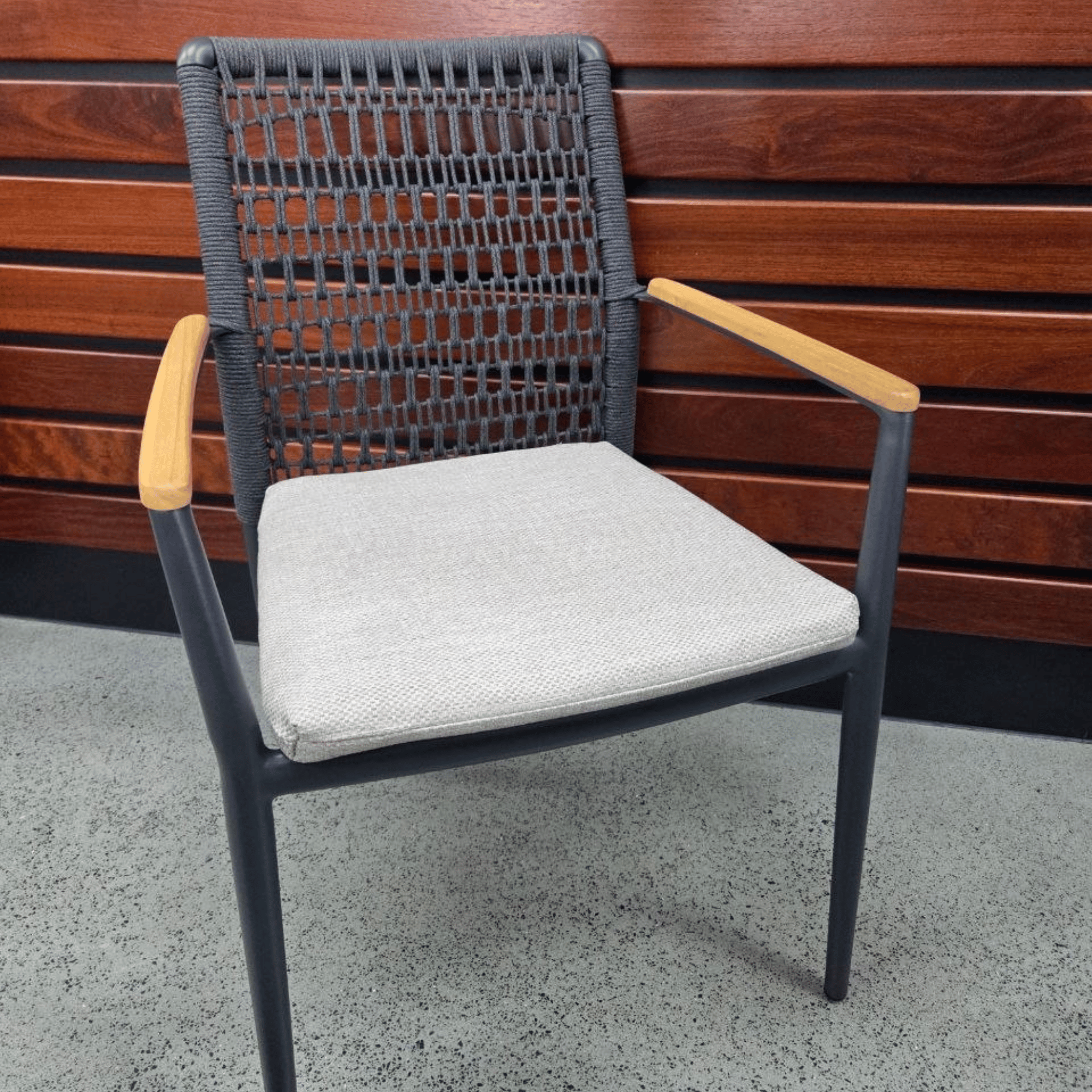 Addis Dining Chair - Charcoal/Oatmeal on concrete floor with wooden background